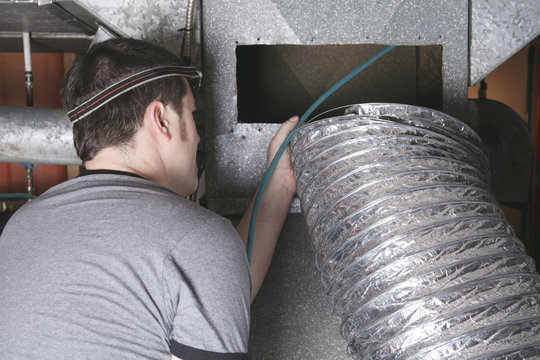 A ventilation cleaner man at work with tool