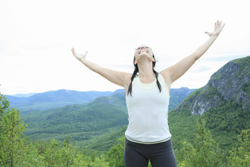 Female hiker with backpack walking and smiling on a country trai