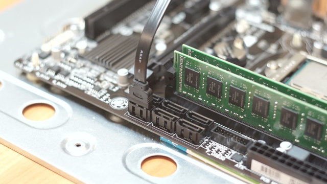 Man Connecting SATA cable to computer motherboard, close up