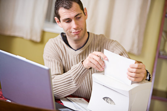 Finances: Man Putting Paper Into Shredder