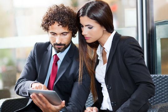 Two business people using a digital tablet