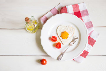 Heart Shaped Egg on the plate with tomatoes on the table