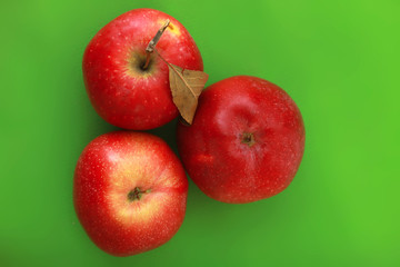 three apples on green