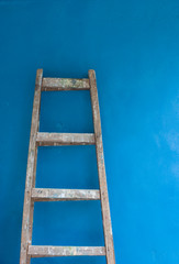 Lladder against blue wall