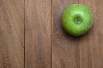 Granny Smith apple on brown wood