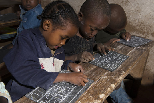 des enfants écrivent sur une ardoise à MADAGASCAR