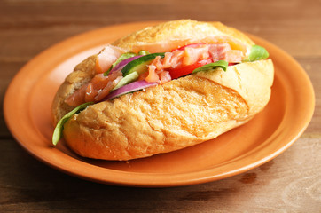 Sandwich with salmon on wooden background