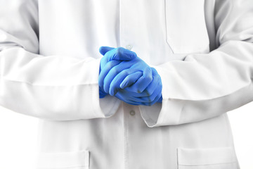 Doctor hands in sterile gloves on background