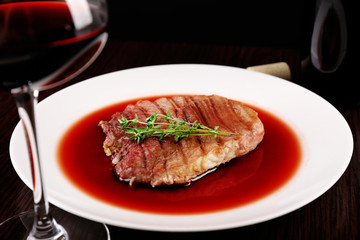 Glass of wine with grilled steak in wine sauce