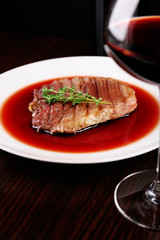 Glass of wine with grilled steak in wine sauce