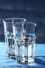 Two glasses of water on table on wooden background