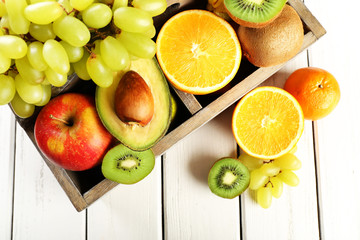 Assortment of fruits in box on wooden table