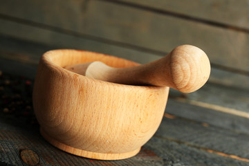 Mixture of peppers in mortar on wooden background