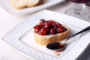 Fresh bread with jam on plate on table close up