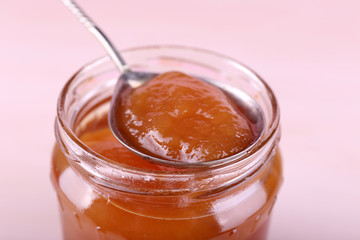 Jar of tasty jam on wooden background