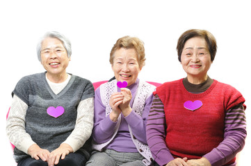 ピンクのハートを持っている3人の仲良しおばあちゃん