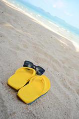 Fototapeta na wymiar Sandal and sunglasses at the beach