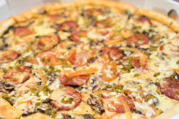 pizza with sausages, tomatoes and spinach