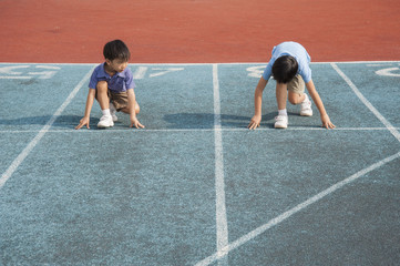 Two boys run on track