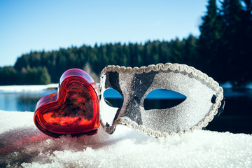 Mask with a heart in the snow landscape