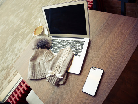 Woolen Hat And Mitten With Laptop On A Table