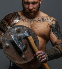 Male full of brutality holding shield and axe