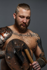 Male full of brutality holding shield and axe