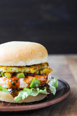 Homemade fish burger with salmon, avocado and pineapple.Close up