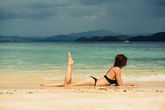 Sexy young woman lying on the beach