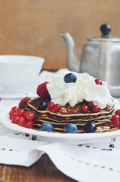 Breakfast with whipped cream pancakes and fresh berries