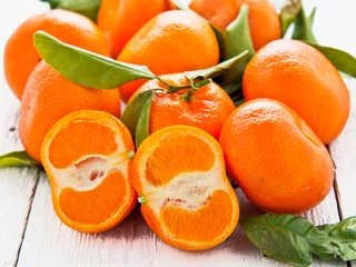 Poster Fresh mandarin fruits on white wood background © mubus