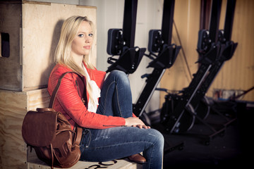 Fototapeta na wymiar woman portrait - woman sitting on a box in a fitness studio
