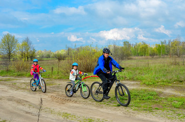 Fototapeta premium Happy family on bikes, father cycling with kids, family sport