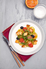 fresh vegetable salad with mozzarella on grey