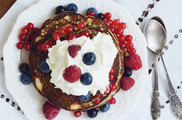 Homemade thin pancakes with whipped cream and fresh berries