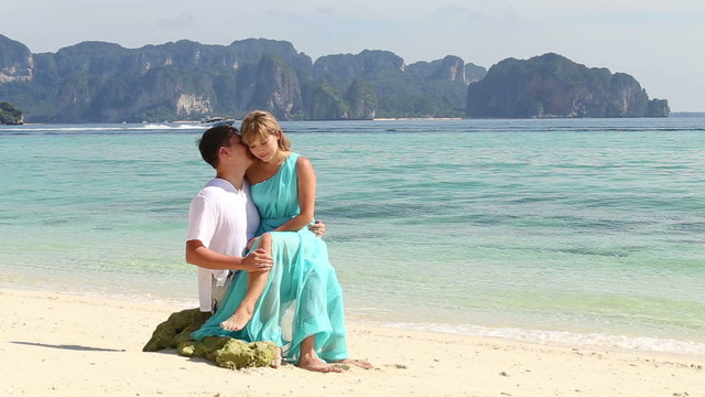 attractive blonde asian girl kiss handsome man sitting on his kn