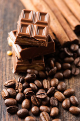 Chocolate bar and cofee beans on wooden table