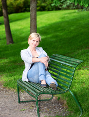 woman sitting on bench in park vertical