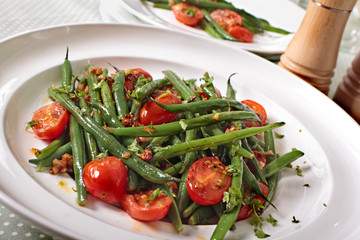 Green beans and tomato salad on white plate