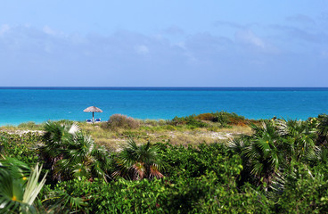 The view on the bright blue ocean with small umbrella at the sid