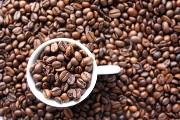 Sfondo chicchi caffè con tazzina piena di chicchi