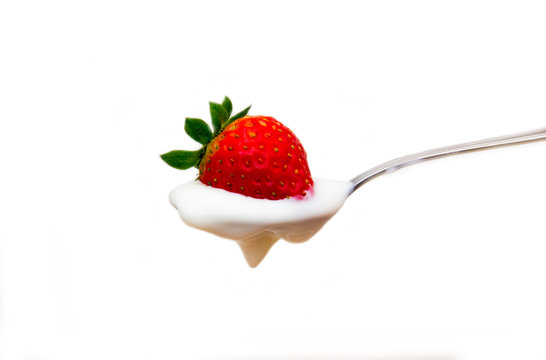 Yogurt with strawberry on spoon on white background
