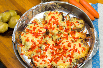 frying meat under the cheese laying on a round metall dish