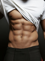 Closeup photo of an athletic guy with perfect abs - obrazy, fototapety, plakaty