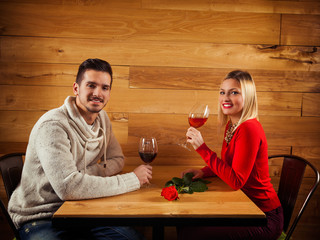 Young couple on a date sitting in a restaurant drinking wine