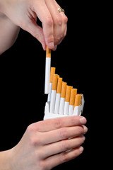 Packs of cigarettes and hand isolated on black background