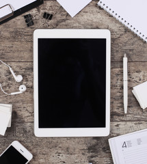 empty tablet with notebook on the wooden desk background