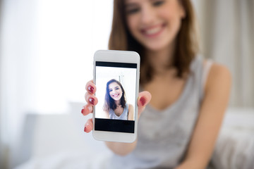 Happy woman making selfie photo on smartphone