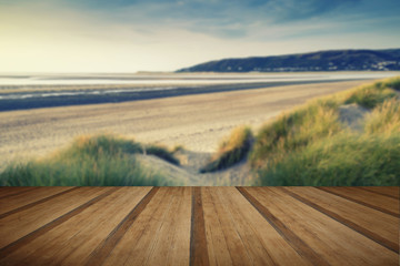 Summer evening landscape view over grassy sand dunes on beach wi