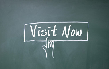 finger click visit now symbol on blackboard